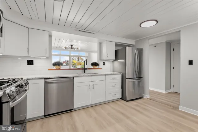 a kitchen with stainless steel appliances granite countertop a refrigerator sink and stove