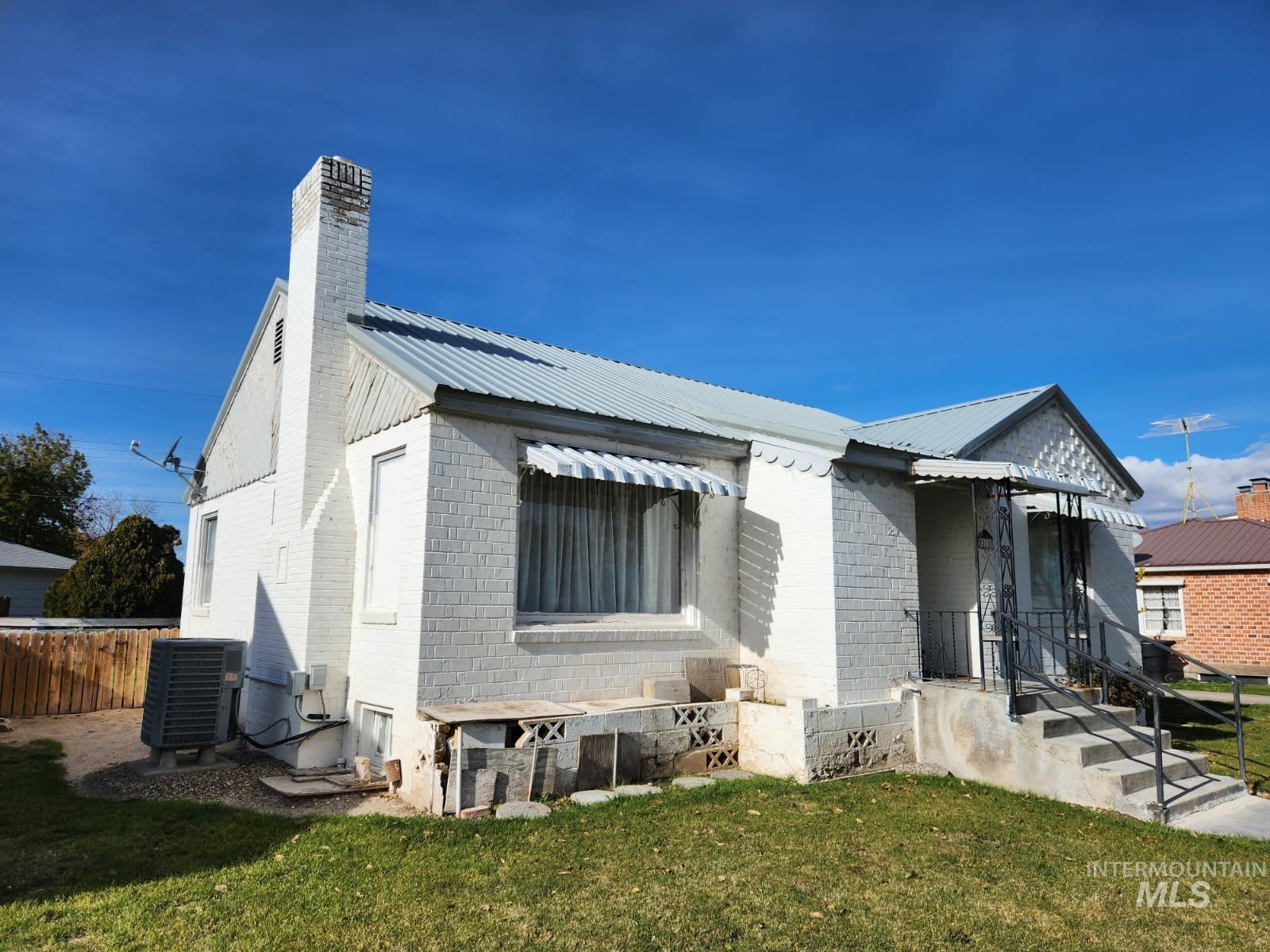 Bungalow with a metal roof and a chimney