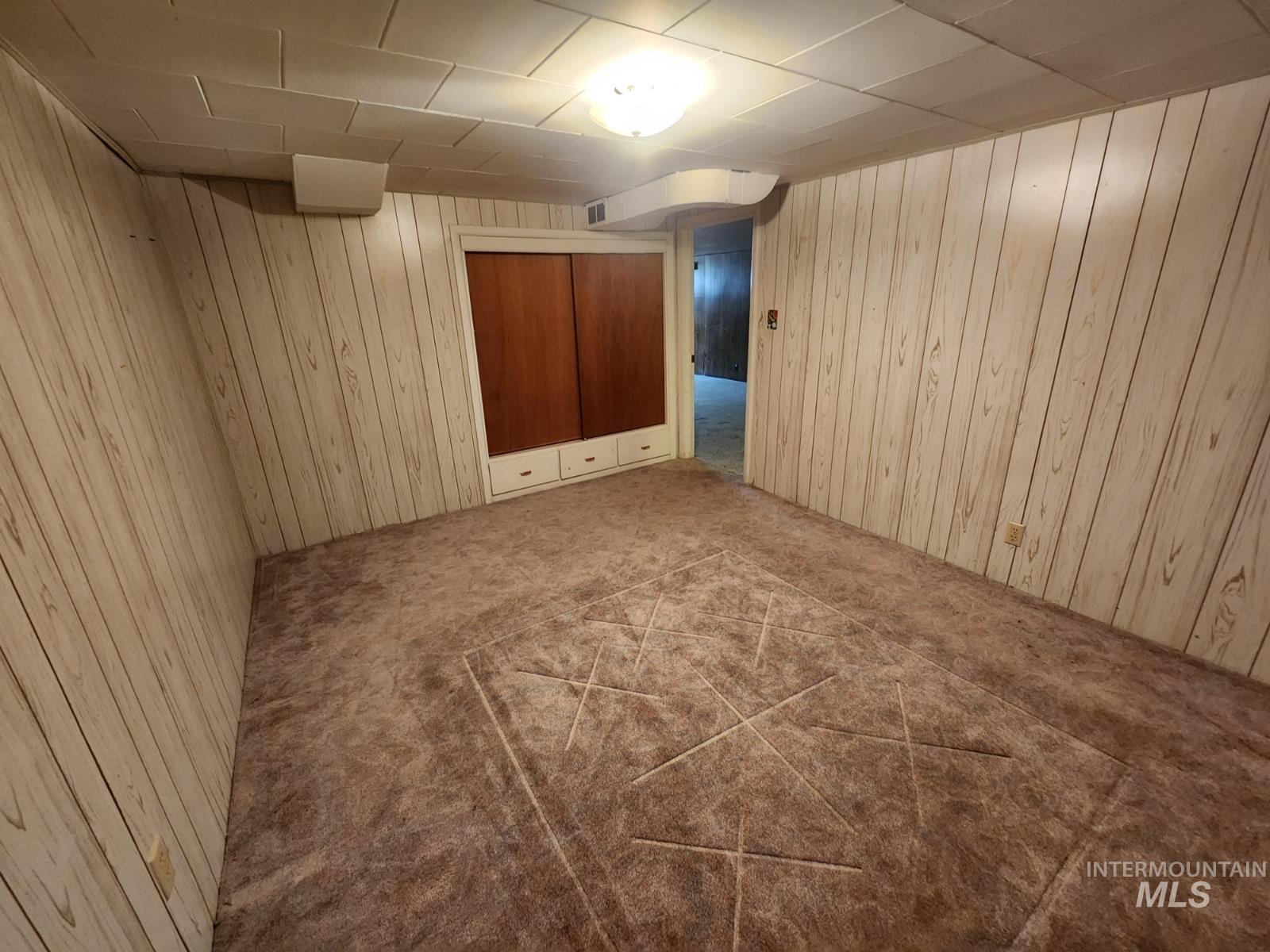 219 South 7th Street Nyssa, OR 97913 - Photo 14 of 29 Empty room featuring carpet floors and wood walls