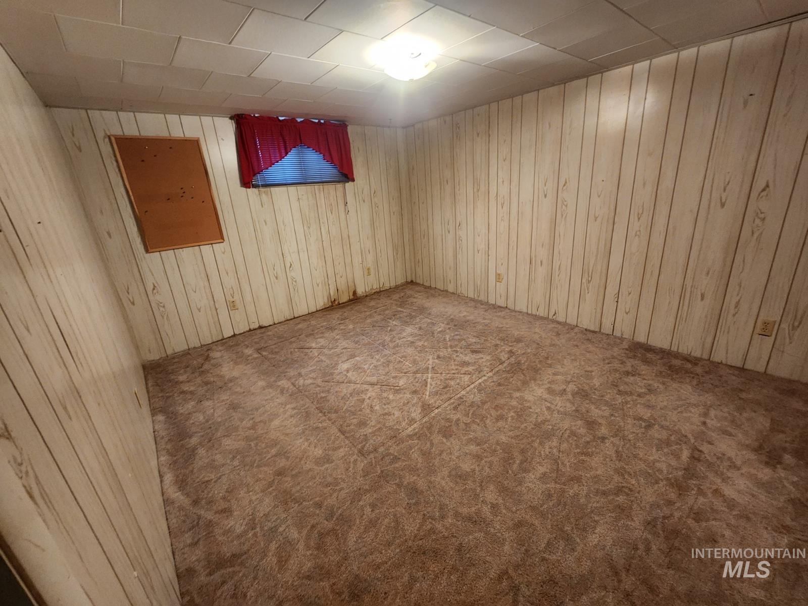 219 South 7th Street Nyssa, OR 97913 - Photo 16 of 29 Empty room featuring carpet floors and wooden walls