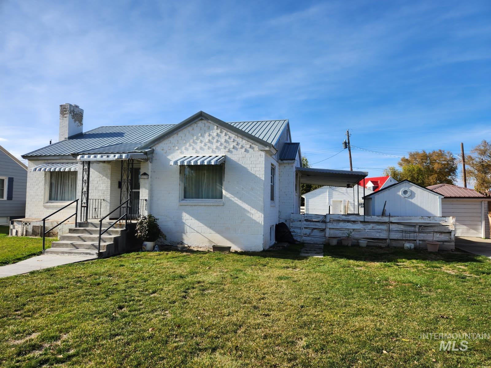 219 South 7th Street Nyssa, OR 97913 - Photo 22 of 29 View of front of home featuring a front yard, a chimney, brick siding, and a metal roof