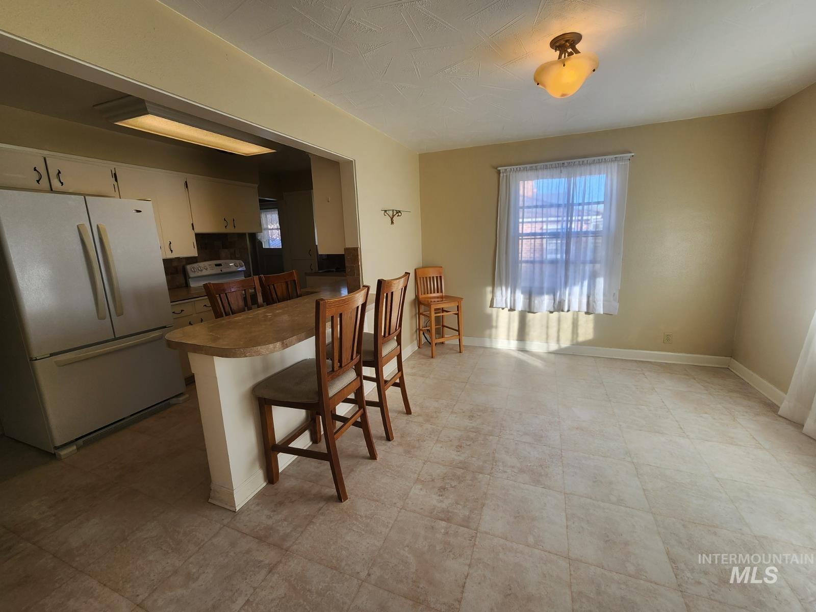 219 South 7th Street Nyssa, OR 97913 - Photo 4 of 29 Kitchen with a kitchen breakfast bar, white appliances, a peninsula, and plenty of natural light
