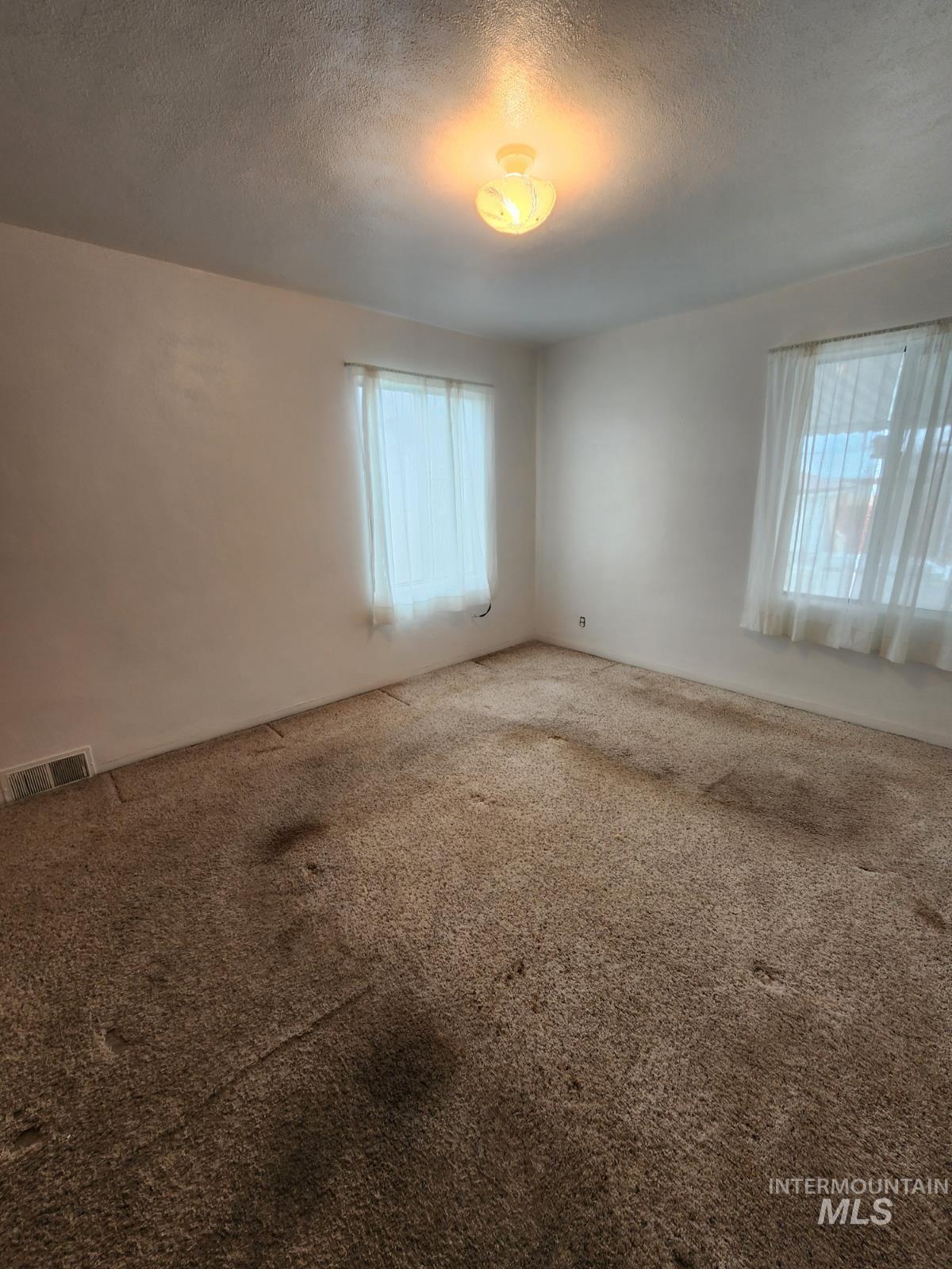 219 South 7th Street Nyssa, OR 97913 - Photo 9 of 29 Carpeted empty room featuring a textured ceiling