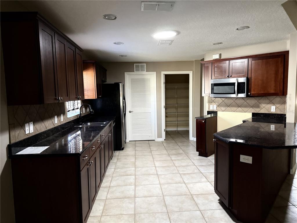 26601 Bull Run Leesburg, FL 34748 - Photo 5 of 15 a kitchen with stainless steel appliances granite countertop a refrigerator and a stove