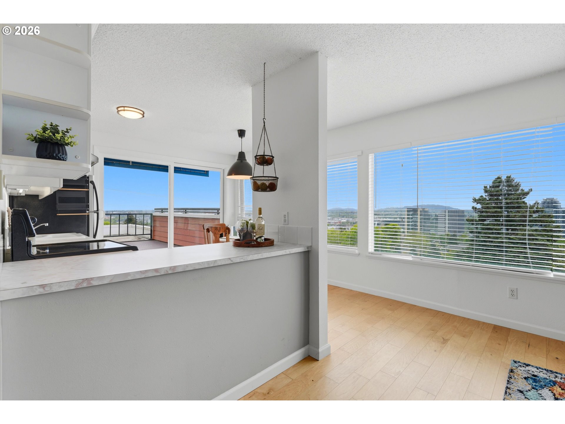3515 Southwest Barbur Boulevard, Unit X3 Portland, OR 97239 - Photo 14 of 33 a kitchen with kitchen island granite countertop a sink cabinets and a large window