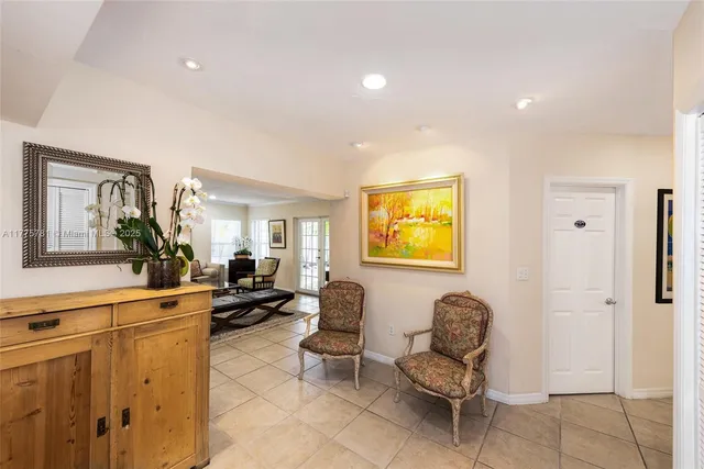 a living room with furniture couches and a view of kitchen appliances