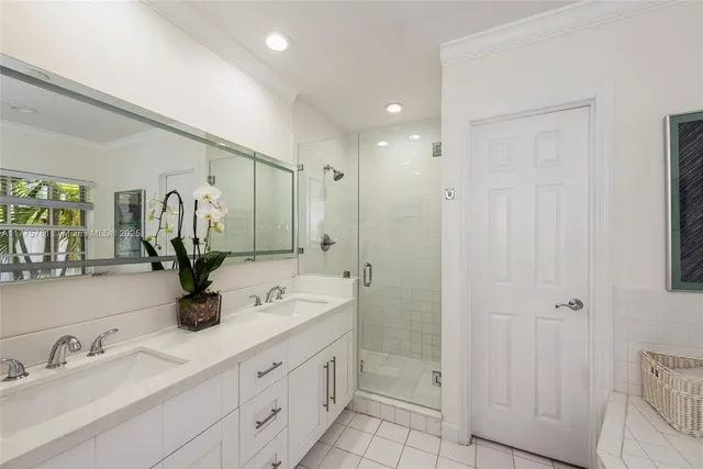 a bathroom with double vanity sink a mirror and shower