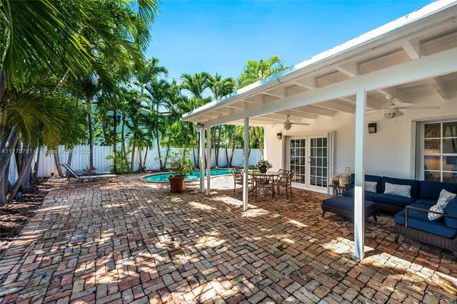 a view of a patio with a table and chairs under an umbrella