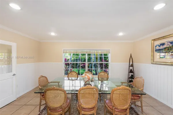 a living room with furniture a window and potted plants