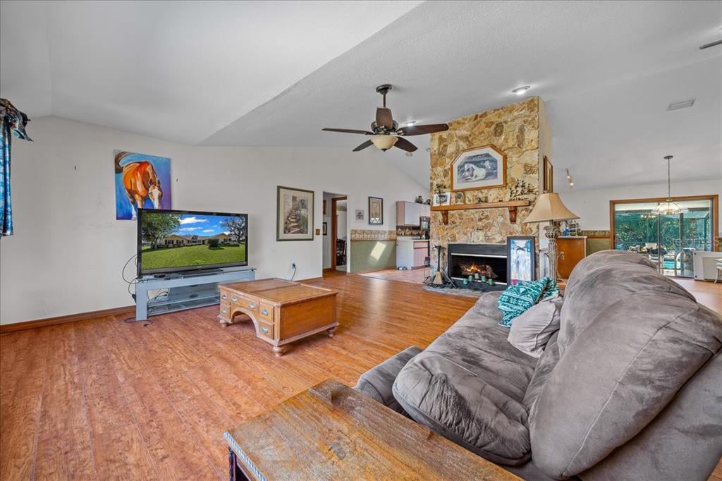 750 Southwest 91st Place Ocala, FL 34476 - Photo 12 of 51 a living room with furniture a fireplace and a flat screen tv