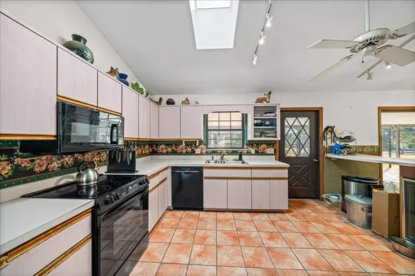 a kitchen with a stove a sink dishwasher a refrigerator with a dining table and chairs