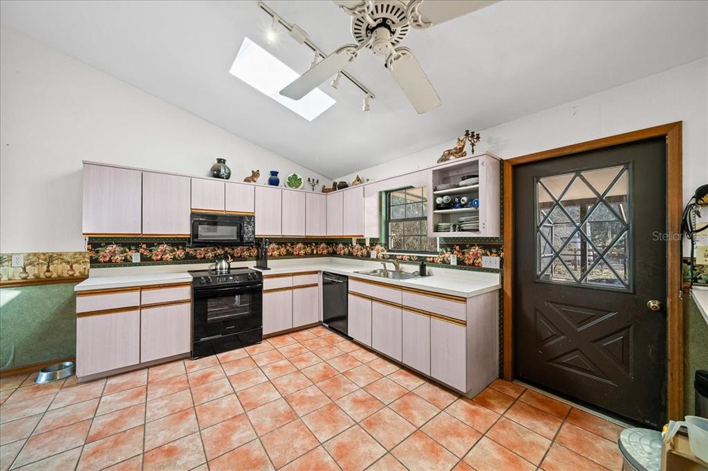 750 Southwest 91st Place Ocala, FL 34476 - Photo 17 of 51 a kitchen with stainless steel appliances granite countertop a stove top oven a sink a dining table and chairs with wooden floor