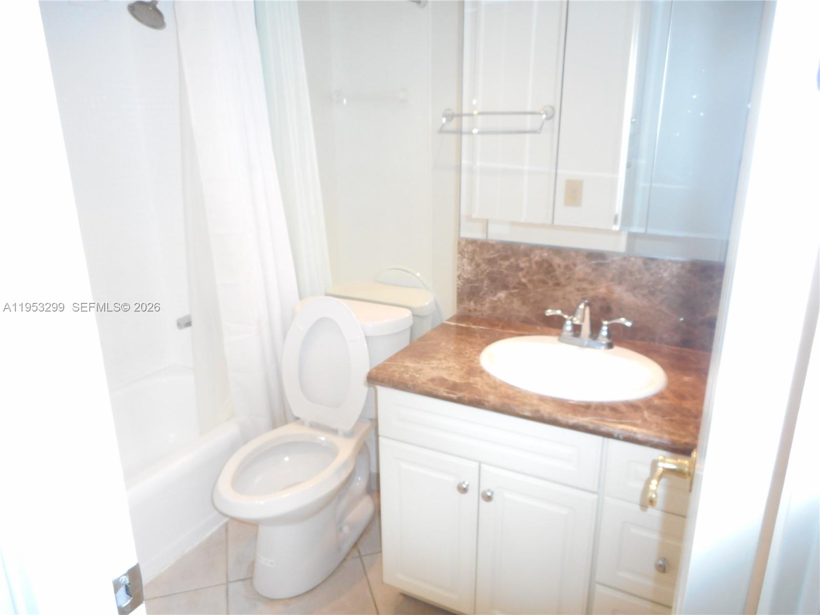10185 Collins Avenue, Unit 1002 Bal Harbour, FL 33154 - Photo 18 of 27 a bathroom with a granite countertop sink toilet and a mirror
