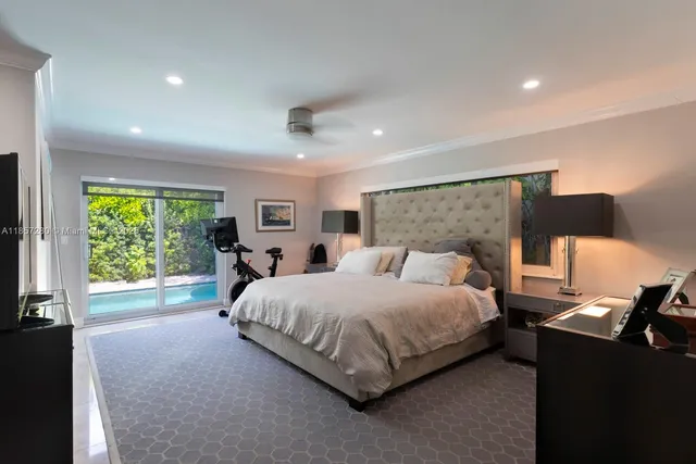 a bedroom with a bed and large windows