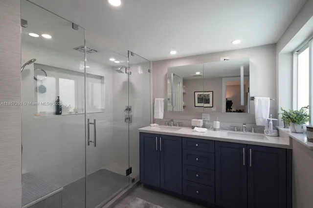 a bathroom with a double vanity sink mirror and shower