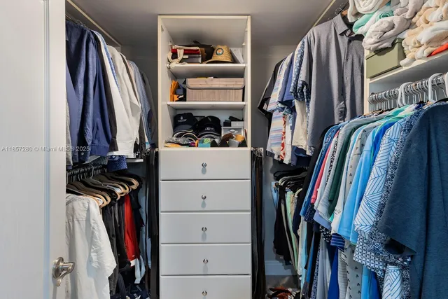 a view of walk in closet with clothes and shoes