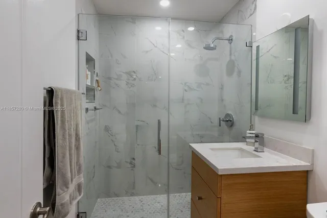 a bathroom with a sink shower and a mirror