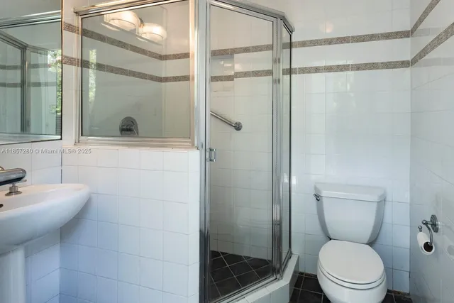 a bathroom with a toilet a sink and shower