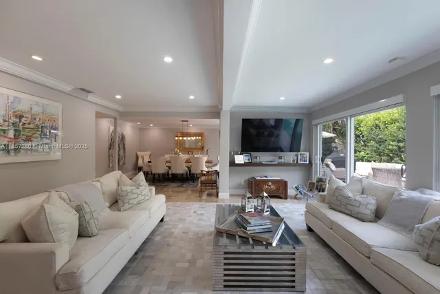 a living room with furniture flat screen tv and a large window