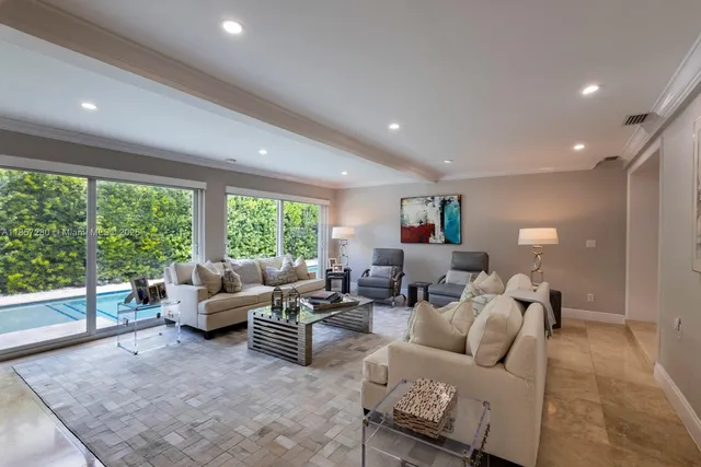a living room with furniture and large windows