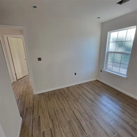 a view of a room with wooden floor and window