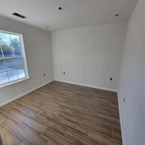 a view of a room with wooden floor and brick walls