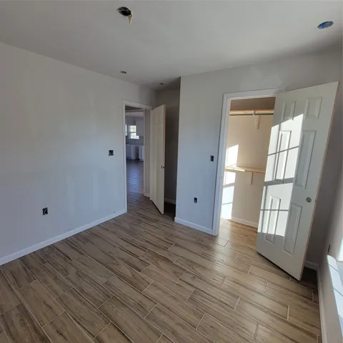 a view of empty room with wooden floor