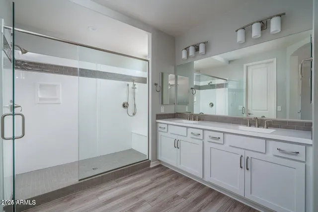 a spacious bathroom with a shower sink and mirror