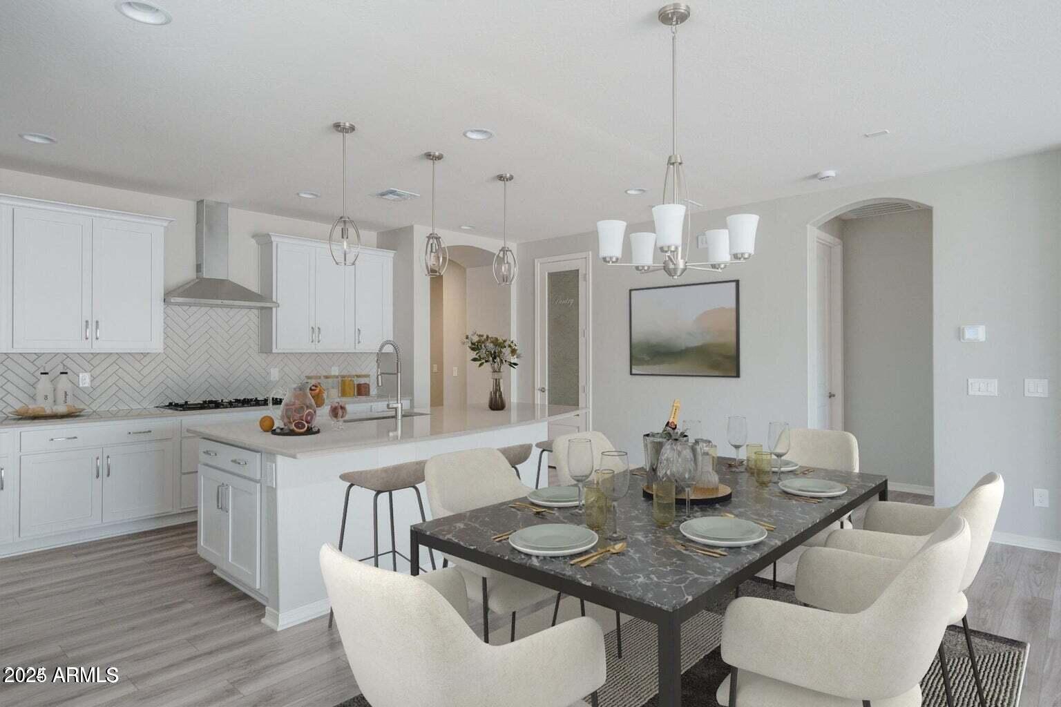 16172 West Alameda Road Surprise, AZ 85387 - Photo 4 of 53 a kitchen with stainless steel appliances kitchen island granite countertop a sink a stove a dining table and chairs