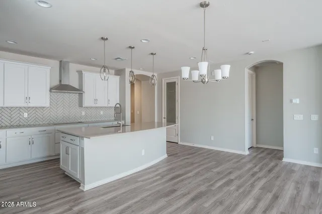 a kitchen that has a lot of cabinets and wooden floor