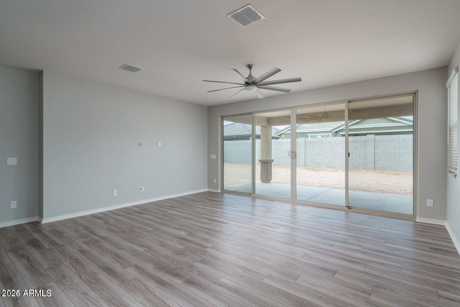 16172 West Alameda Road Surprise, AZ 85387 - Photo 7 of 53 a view of an empty room with wooden floor and a window
