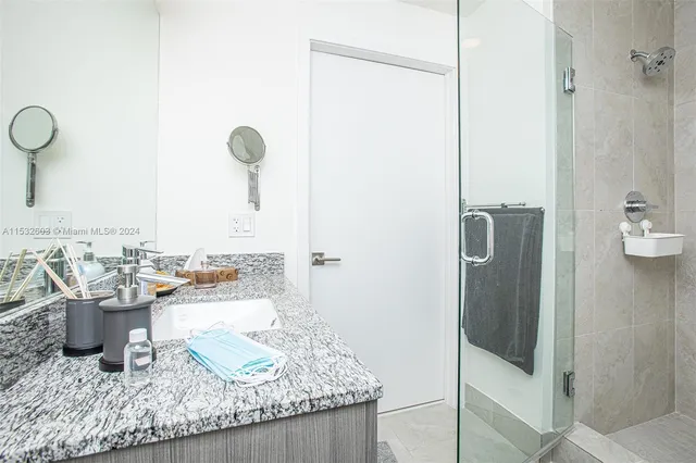 a bathroom with a granite countertop sink and a mirror