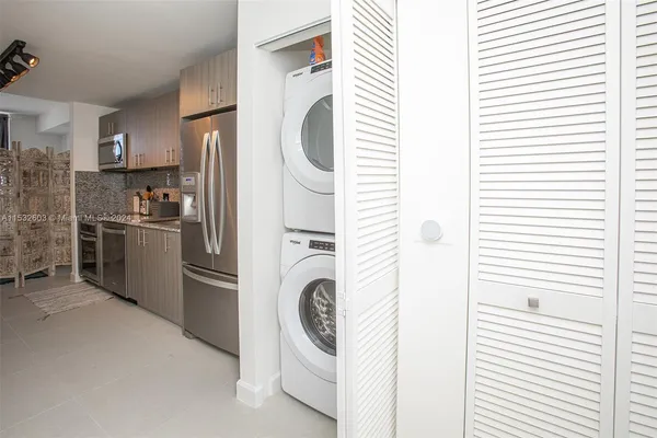 a kitchen with stainless steel appliances granite countertop a sink and a refrigerator