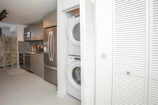 a kitchen with stainless steel appliances granite countertop a sink and a refrigerator