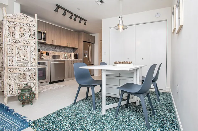 a kitchen with stainless steel appliances kitchen island granite countertop a sink and chairs
