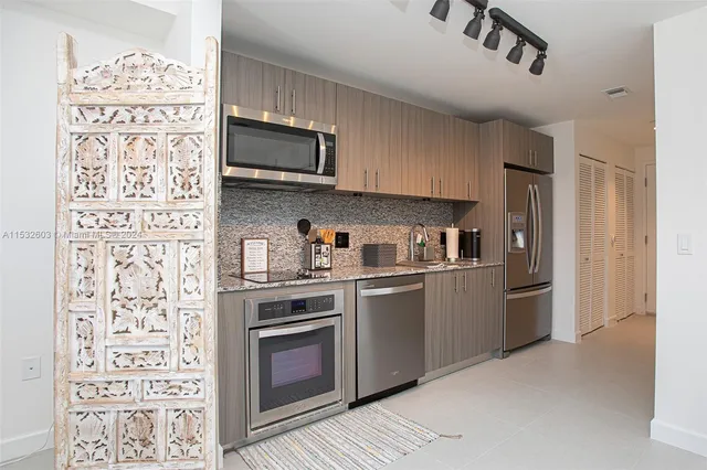 a kitchen with stainless steel appliances granite countertop a refrigerator and a stove top oven