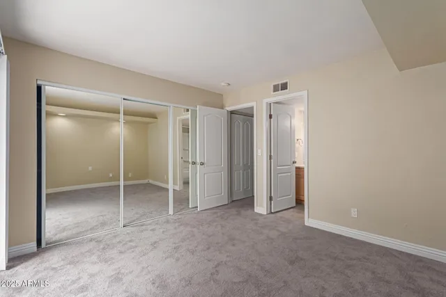 an empty room with closet and a bathroom