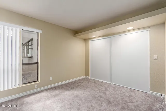 a view of an empty room with closet and a window