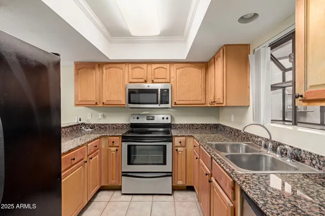 a kitchen with stainless steel appliances granite countertop a stove a sink and a microwave