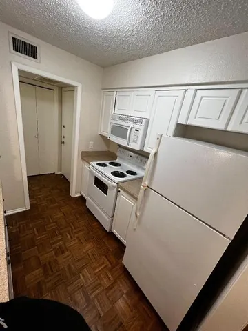 a kitchen with a refrigerator and a stove