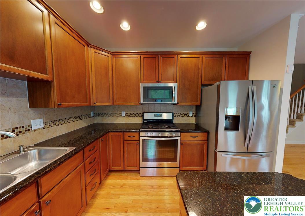 1824 Big Ridge Drive East Stroudsburg, PA 18302 - Photo 8 of 46 a kitchen with stainless steel appliances granite countertop a refrigerator a stove a sink and a microwave