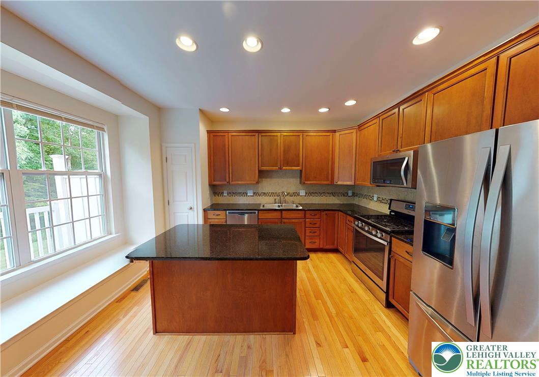 1824 Big Ridge Drive East Stroudsburg, PA 18302 - Photo 10 of 46 a kitchen with stainless steel appliances granite countertop a refrigerator a stove top oven a sink and dishwasher with wooden floor
