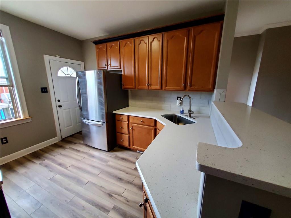 905 Deely Street Pittsburgh, PA 15217 - Photo 12 of 19 a kitchen with granite countertop a refrigerator a sink and wooden cabinets