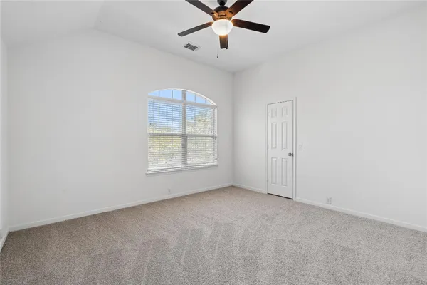 an empty room with fan and windows