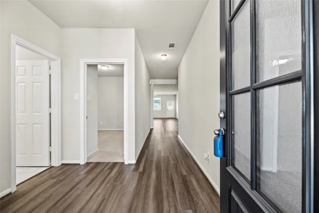 a view of a hallway with wooden floor and staircase