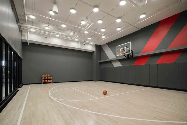 a large kitchen with stainless steel appliances granite countertop a refrigerator a stove and a wooden floors