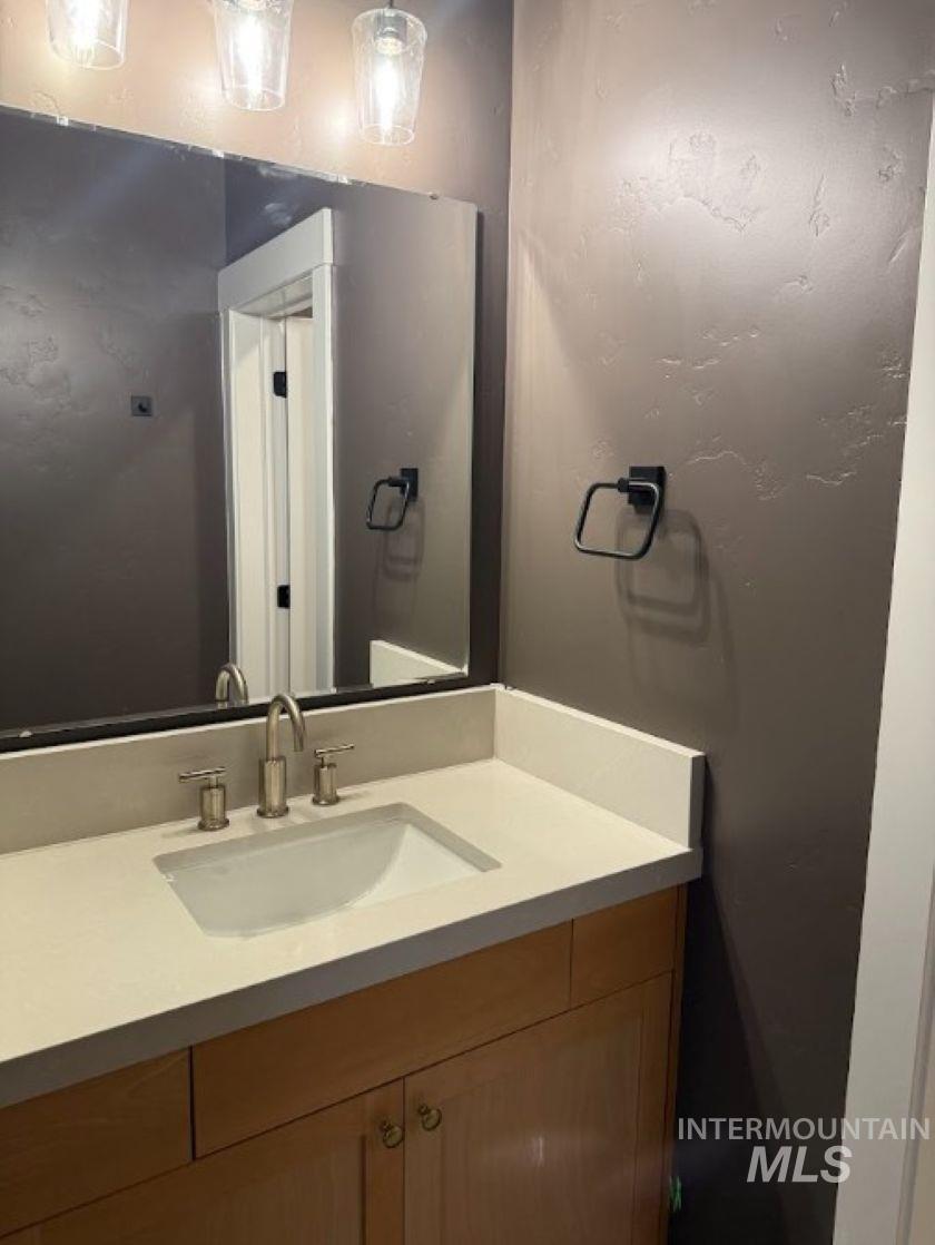 755 West Wrangler Street Meridian, ID 83646 - Photo 16 of 35 Vanity featuring a light-toned countertop with integrated sink, brushed nickel faucet, and wood-finish cabinetry