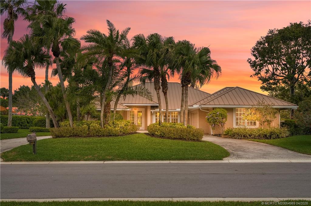 6273 Southeast Baltusrol Terrace Stuart, FL 34997 - Photo 1 of 68 a front view of a house with a garden and a yard