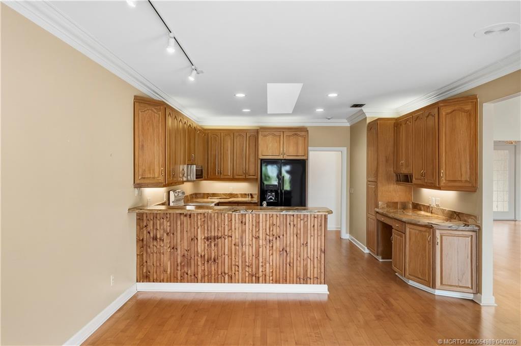 6273 Southeast Baltusrol Terrace Stuart, FL 34997 - Photo 12 of 68 a kitchen with stainless steel appliances granite countertop a stove a sink and a refrigerator