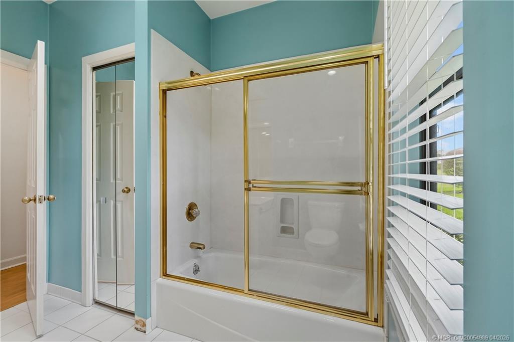 6273 Southeast Baltusrol Terrace Stuart, FL 34997 - Photo 26 of 68 a bathroom with a glass shower door